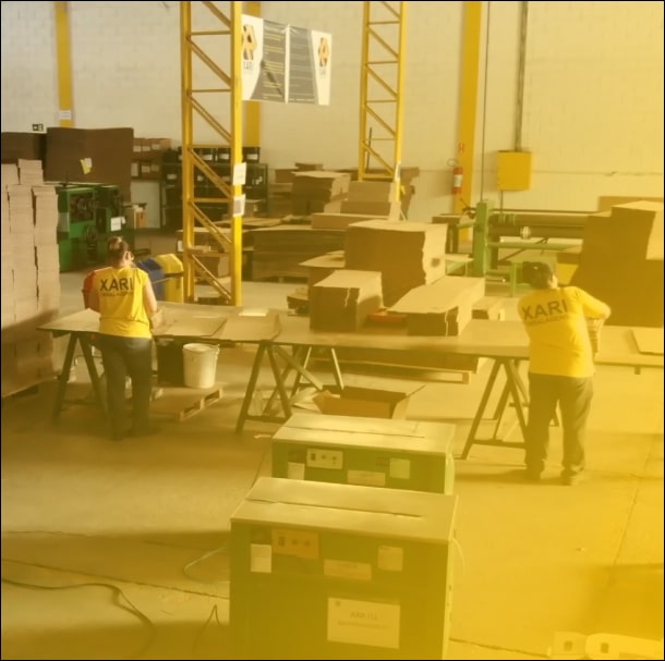 Imagem duas mulheres trabalhando montando caixas de papelão